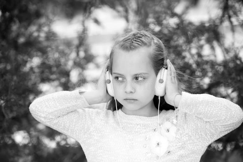 Petite fille mignonne appréciant la musique utilisant des écouteurs photographie stock Petite fille mignonne appréciant la musique utilisant des écouteurs photographie stock