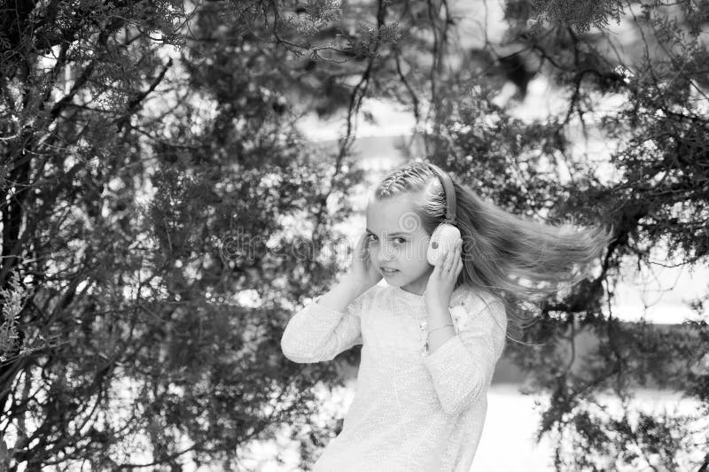 Petite fille mignonne appréciant la musique utilisant des écouteurs images stock Petite fille mignonne appréciant la musique utilisant des écouteurs images stock