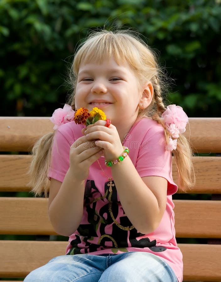 Petite fille mignonne avec des fleurs. photographie stock Petite fille mignonne avec des fleurs. photographie stock
