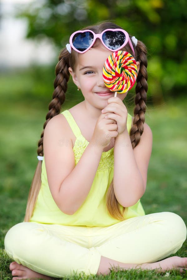 Petite fille mignonne avec la grande lucette colorée photo stock Petite fille mignonne avec la grande lucette colorée photo stock