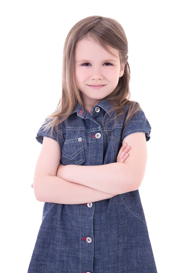 Petite fille mignonne drôle dans la robe de denim avec l'isolat croisé de mains image libre de droits Petite fille mignonne drôle dans la robe de denim avec l'isolat croisé de mains image libre de droits
