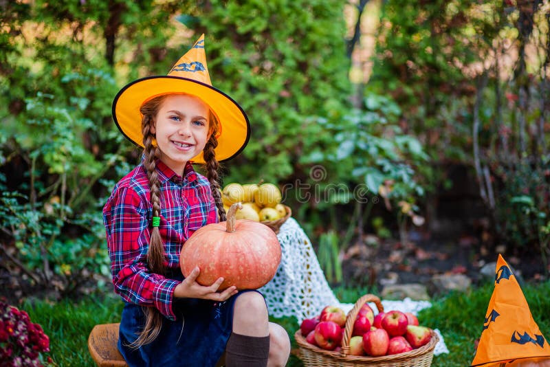Petite fille mignonne embrasse une citrouille dans le jardin d'automne photos libres de droits Petite fille mignonne embrasse une citrouille dans le jardin d'automne photos libres de droits
