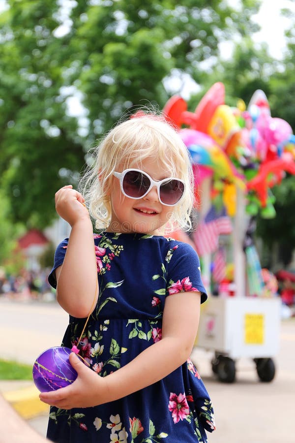 Petite fille mignonne jouant avec le yo-yo de ballon d'eau au défilé américain de petite ville photos libres de droits