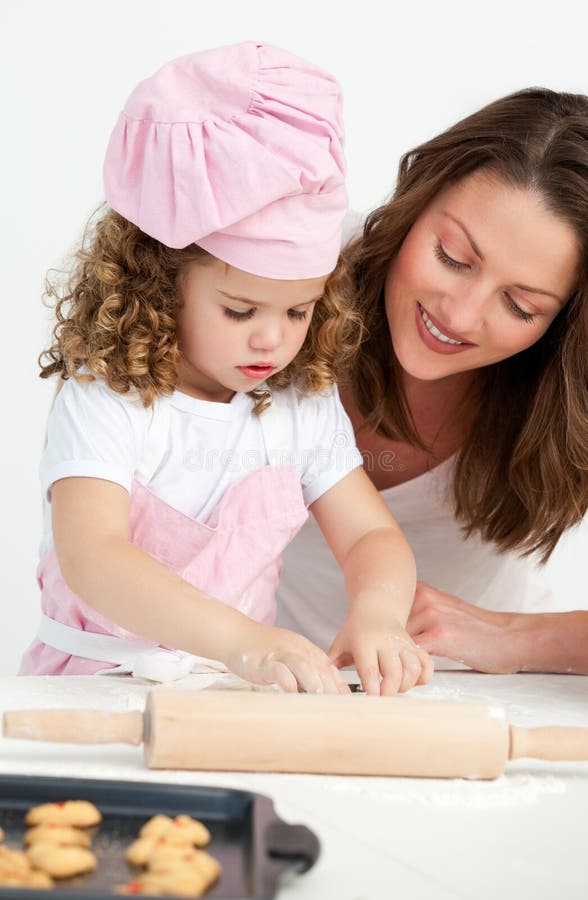 Petite fille préparant une pâte avec sa mère photographie stock libre de droits Petite fille préparant une pâte avec sa mère photographie stock libre de droits