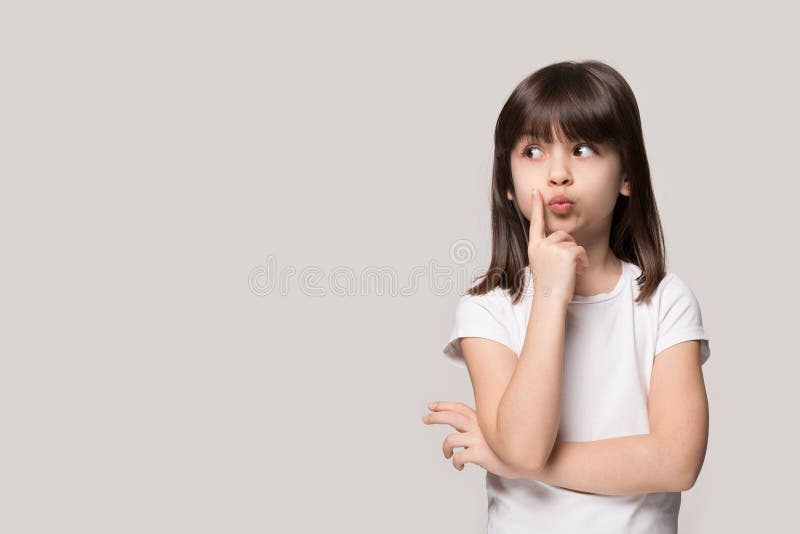 Petite fille réfléchie regardant loin la pensée d'isolement sur le fond gris images libres de droits Petite fille réfléchie regardant loin la pensée d'isolement sur le fond gris images libres de droits