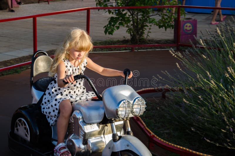 Petite Fille Sur Une Moto En Jouet Dans Le Parc Photo stock - Image du  amour, nourrisson: 239710076