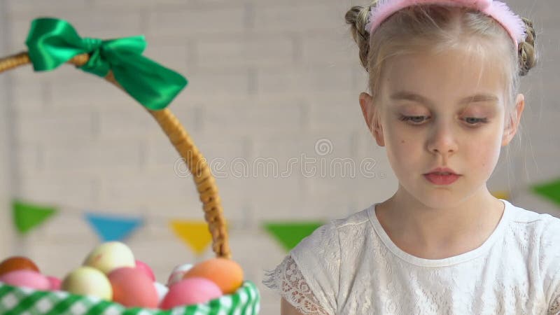 Petite hôtesse adorable emballant le panier de Pâques avec les oeufs teints colorés, tradition banque de vidéos