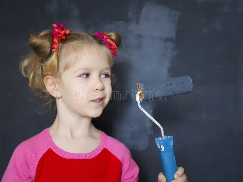 Petite peinture de sourire de fille le mur avec la peinture magnétique photo libre de droits Petite peinture de sourire de fille le mur avec la peinture magnétique photo libre de droits