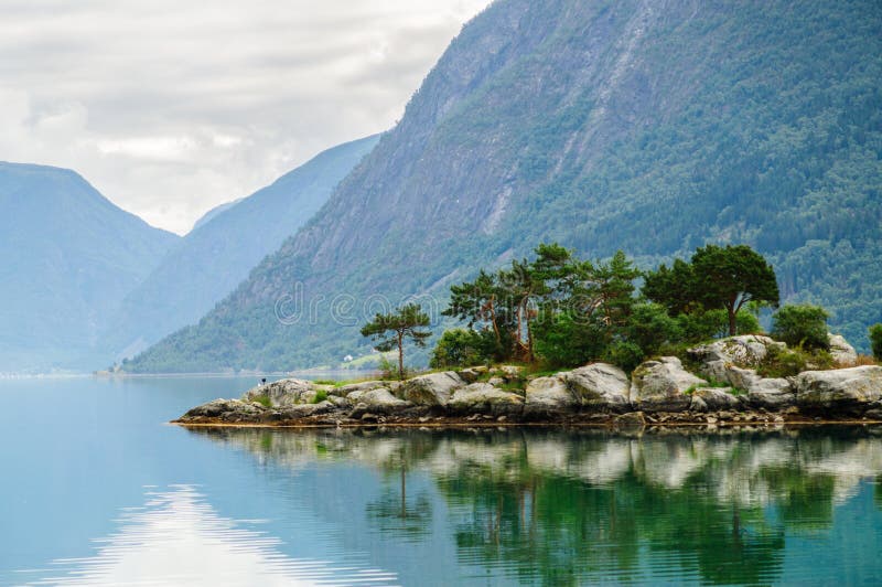 Petite île avec le fond de montagnes au fjord norvégien images libres de droits Petite île avec le fond de montagnes au fjord norvégien images libres de droits