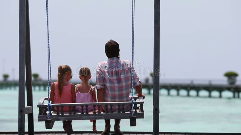 Petites filles adorables et jeune père sur l'oscillation banque de vidéos