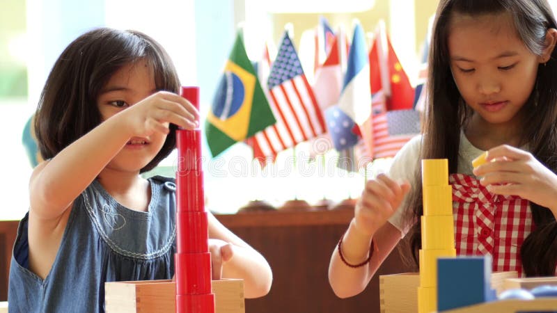 Petites filles asiatiques empilant des blocs de montessori