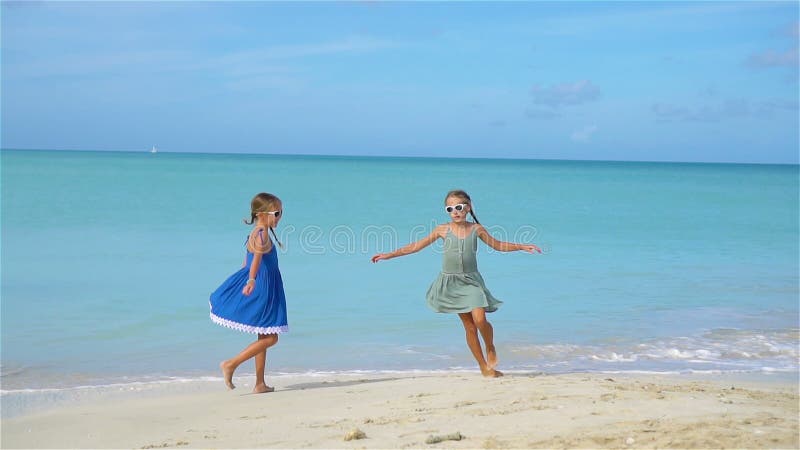 Petites filles ayant l'amusement à la plage tropicale pendant jouer de vacances d'été clips vidéos