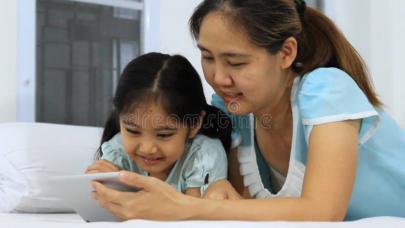 Petites mère et fille asiatiques à l'aide du comprimé