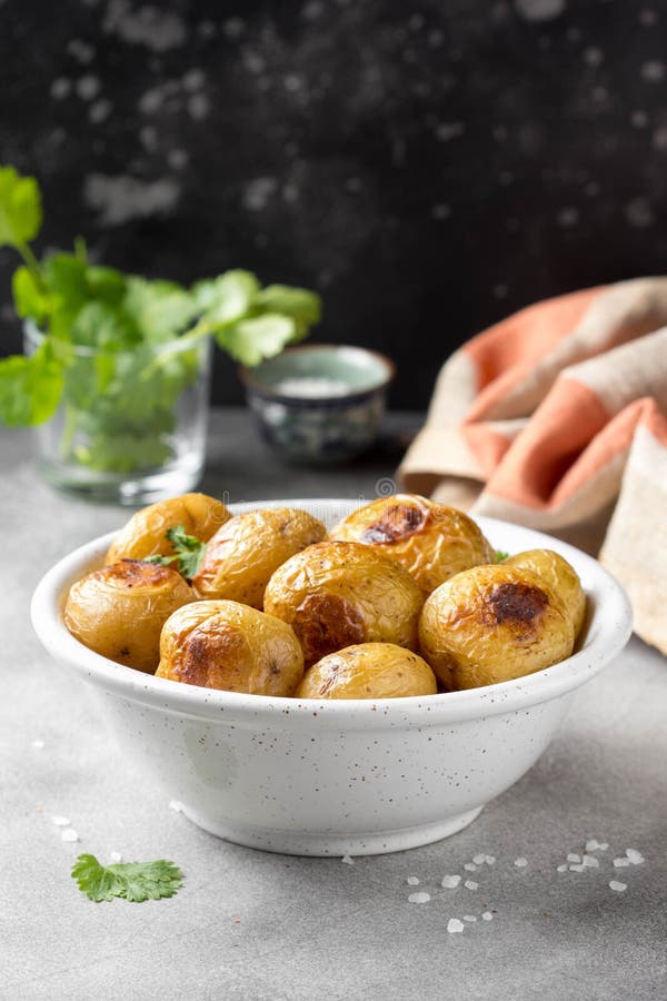 Petites pommes de terre enti?res (cuites au four) frites avec les herbes et le sel dans la cuvette, cro?te vermeille, nourriture images stock Petites pommes de terre enti?res (cuites au four) frites avec les herbes et le sel dans la cuvette, cro?te vermeille, nourriture images stock