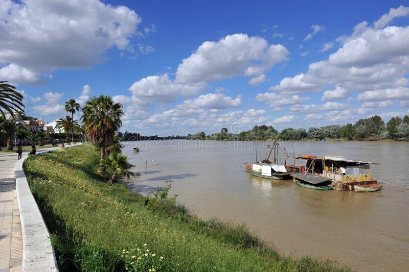 Petits bateaux sur la rivière du Guadalquivir comme elle traverse le del province de Rio, Séville de corions, Andalousie, Espagne image stock Petits bateaux sur la rivière du Guadalquivir comme elle traverse le del province de Rio, Séville de corions, Andalousie, Espagne image stock