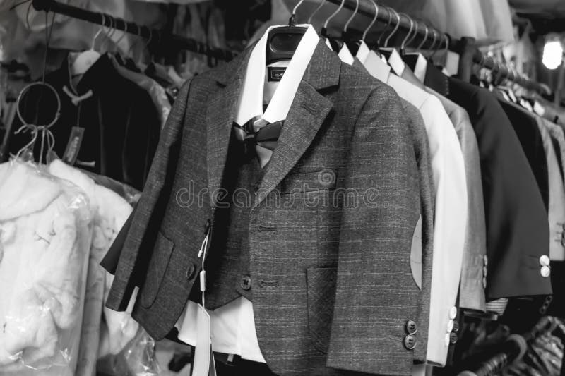 Petits costumes de gantleman accrochant sur un cintre image libre de droits Petits costumes de gantleman accrochant sur un cintre image libre de droits