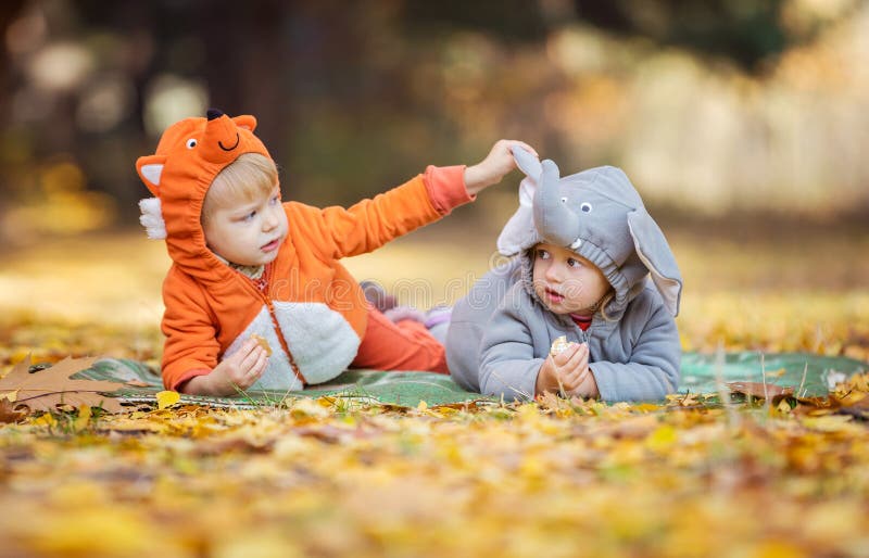 Petits enfants chez les costumes animaux jouant dans la forêt d'automne photo libre de droits Petits enfants chez les costumes animaux jouant dans la forêt d'automne photo libre de droits