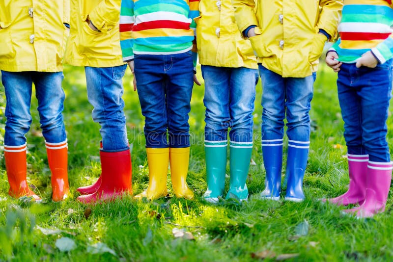 Petits enfants, garçons ou filles dans les jeans et la guêpe dans des bottes de pluie colorées photo stock Petits enfants, garçons ou filles dans les jeans et la guêpe dans des bottes de pluie colorées photo stock