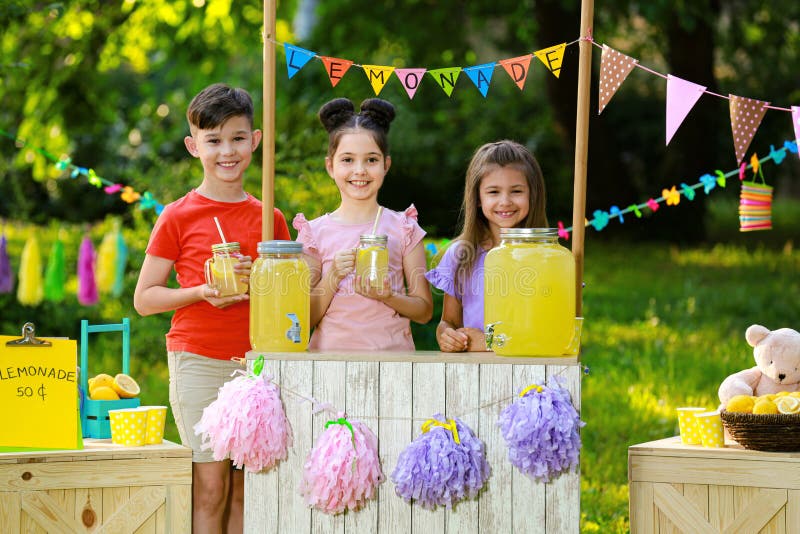 Petits enfants mignons au stand de limonade Été régénérant la boisson naturelle photo stock Petits enfants mignons au stand de limonade Été régénérant la boisson naturelle photo stock