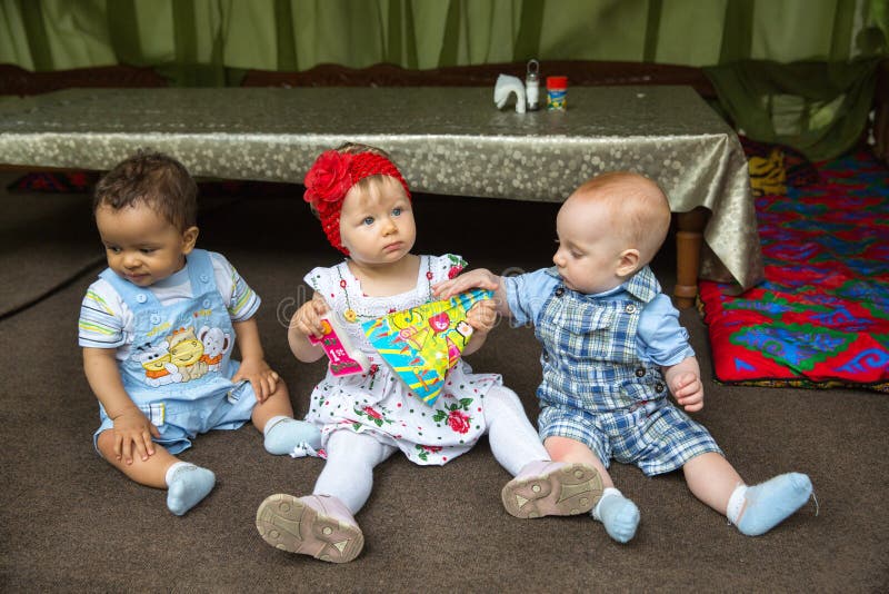 Petits trois enfants : garçons américains et caucasiens noirs et bébé russe situant photographie stock libre de droits Petits trois enfants : garçons américains et caucasiens noirs et bébé russe situant photographie stock libre de droits