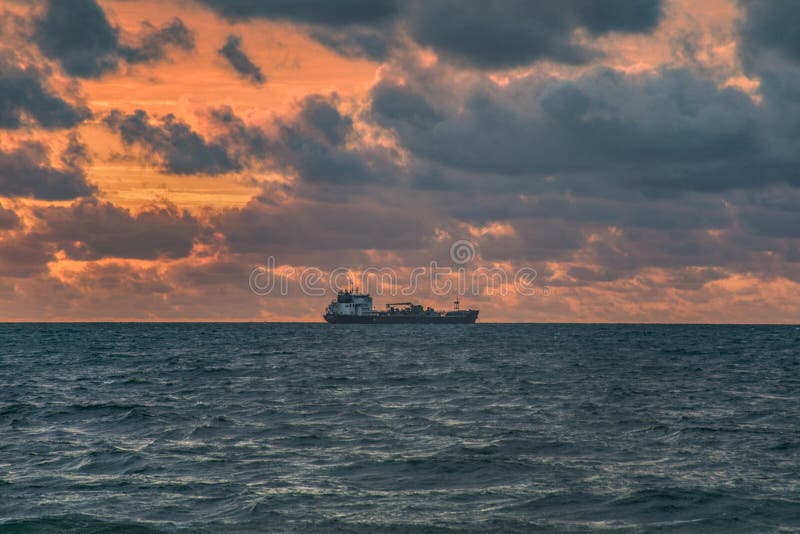 Petroleiro de óleo fora da costa no nascer do sol fotografia de stock Petroleiro de óleo fora da costa no nascer do sol fotografia de stock