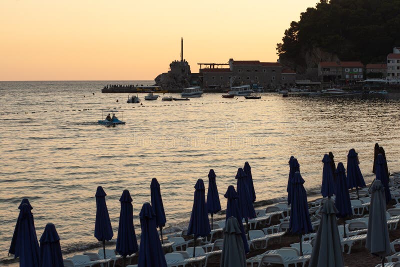 PETROVAC MONTENEGRO - JULI 20, 2018: Sikt från kajen av Petrovac till den gamla slotten och Adriatiskt havet, sommar, solnedgångl royaltyfria bilder PETROVAC MONTENEGRO - JULI 20, 2018: Sikt från kajen av Petrovac till den gamla slotten och Adriatiskt havet, sommar, solnedgångl royaltyfria bilder