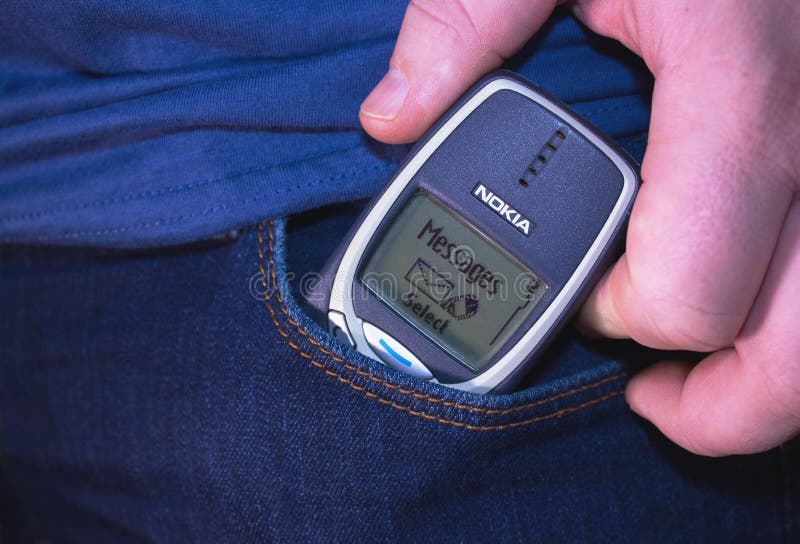 Male hand pulls old Nokia cellphone out of jeans pocket