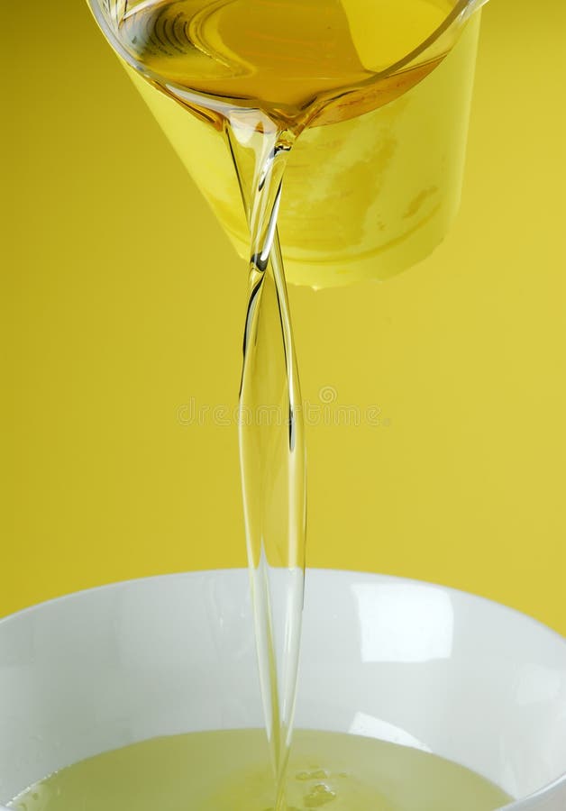 Pouring oil or golden liquid on yellow background. Pouring oil or golden liquid on yellow background