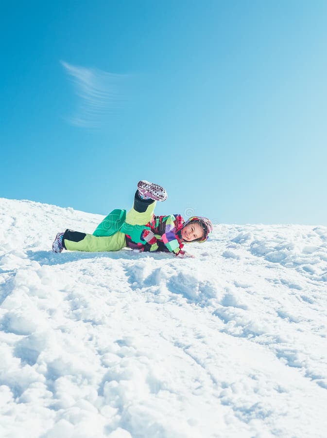 Peu de fille ont l'amusement quand les glissières avalent de la colline de neige Elle est hasard photographie stock libre de droits Peu de fille ont l'amusement quand les glissières avalent de la colline de neige Elle est hasard photographie stock libre de droits