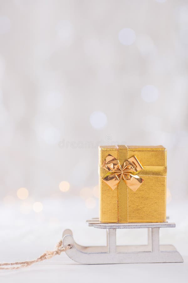 Peu de joli boîte-cadeau sur le traîneau blanc de jouet sur le backgrou léger de bokeh photo libre de droits Peu de joli boîte-cadeau sur le traîneau blanc de jouet sur le backgrou léger de bokeh photo libre de droits