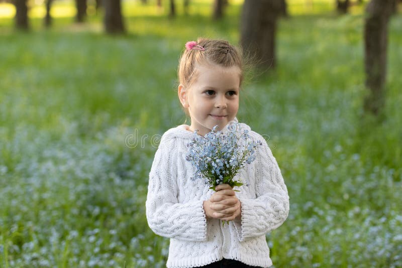 Peu fille avec un bouquet des myosotis des marais images stock Peu fille avec un bouquet des myosotis des marais images stock
