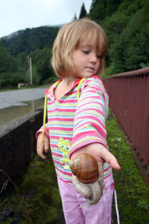Peu fille avec un escargot énorme sur sa paume photos libres de droits Peu fille avec un escargot énorme sur sa paume photos libres de droits