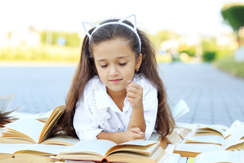 Peu fille futée étudiant des manuels Le concept est de nouveau à l'école, éducation, lecture, passe-temps photos stock Peu fille futée étudiant des manuels Le concept est de nouveau à l'école, éducation, lecture, passe-temps photos stock