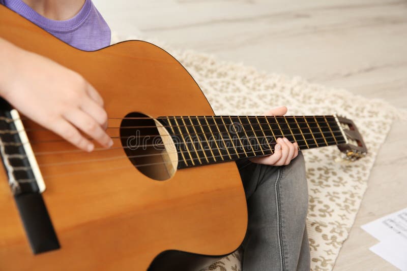 Peu fille jouant la guitare sur le plancher images libres de droits Peu fille jouant la guitare sur le plancher images libres de droits