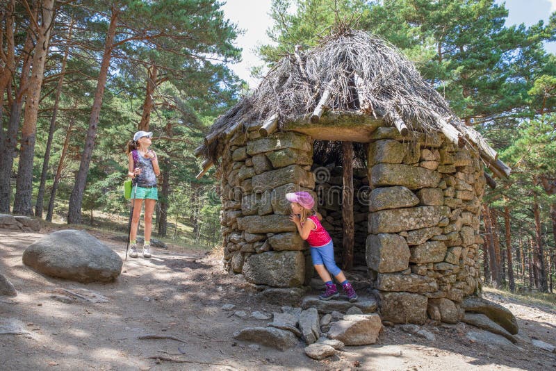 Peu fille jouant le cache-cache avec sa mère dans la hutte antique dans la forêt de montagne de Canencia