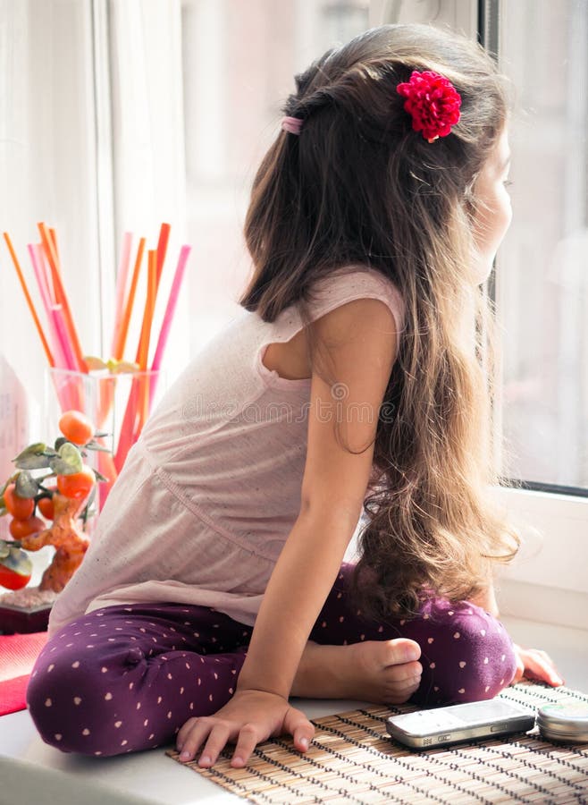 Peu fille sur le fenêtre-filon-couche regardant la fenêtre images stock Peu fille sur le fenêtre-filon-couche regardant la fenêtre images stock