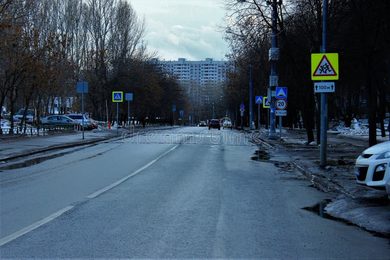 Peu rue de la ville après la pluie Moscou La Russie. Peu rue de la ville après la pluie Asphalte humide Notation routier Voitures Arbres le long de la route Maisons d'habitation Nuages dans le ciel