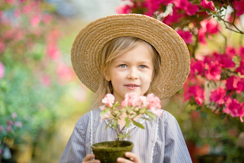 Peuter met bloemmand Meisje die roze bloemen houden stock foto Peuter met bloemmand Meisje die roze bloemen houden stock foto