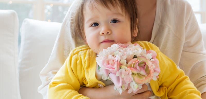 Peuterjongen met zijn bloemen van de moederholding stock afbeeldingen Peuterjongen met zijn bloemen van de moederholding stock afbeeldingen