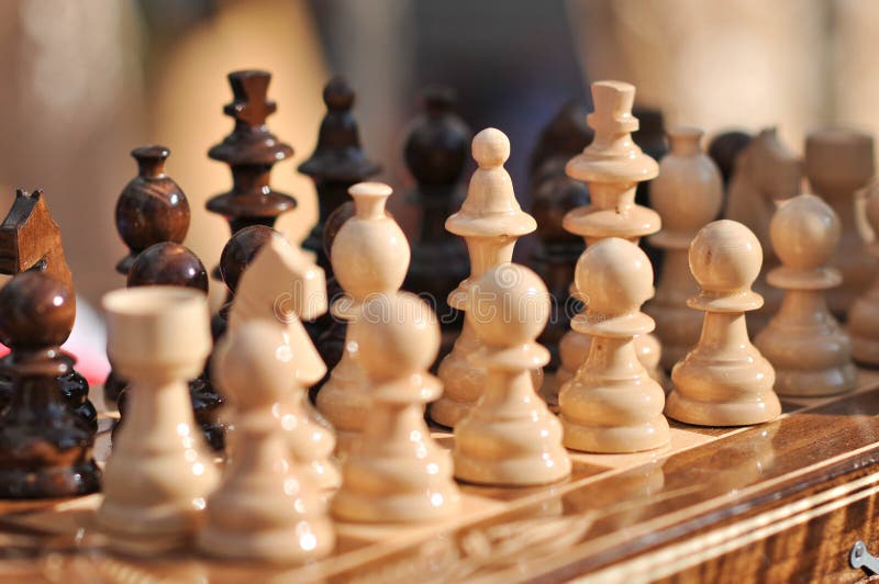 Pezzi degli scacchi in bianco e nero su una scacchiera, primo piano L'insieme di scacchi calcola sulla scheda di gioco immagini stock Pezzi degli scacchi in bianco e nero su una scacchiera, primo piano L'insieme di scacchi calcola sulla scheda di gioco immagini stock