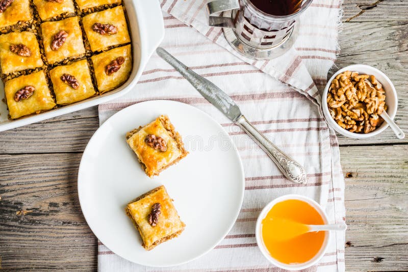 Pieces of baklava with honey and nuts on a plate, top view, rustic, traditional Turkish dessert. Pieces of baklava with honey and nuts on a plate, top view, rustic, traditional Turkish dessert