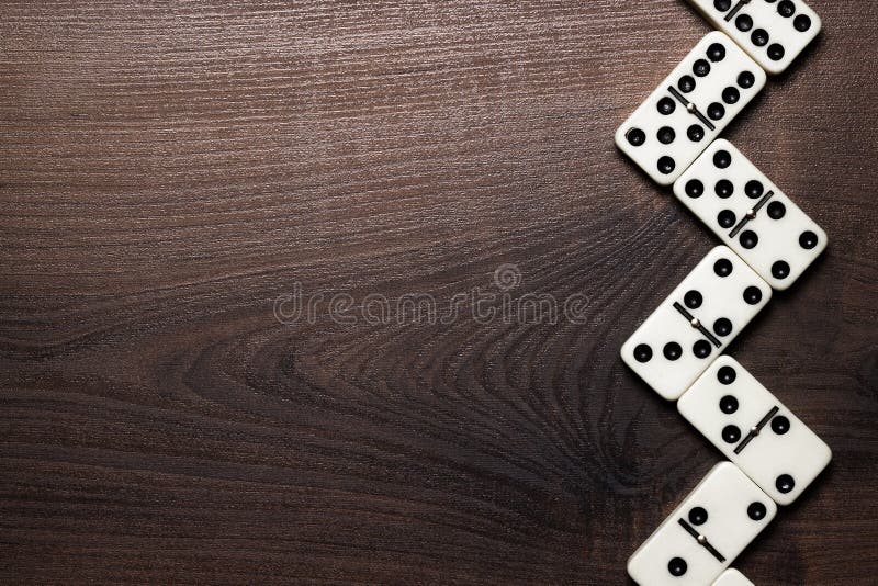 Pezzi di domino che formano zigzag sopra la tavola di legno fotografia stock libera da diritti Pezzi di domino che formano zigzag sopra la tavola di legno fotografia stock libera da diritti