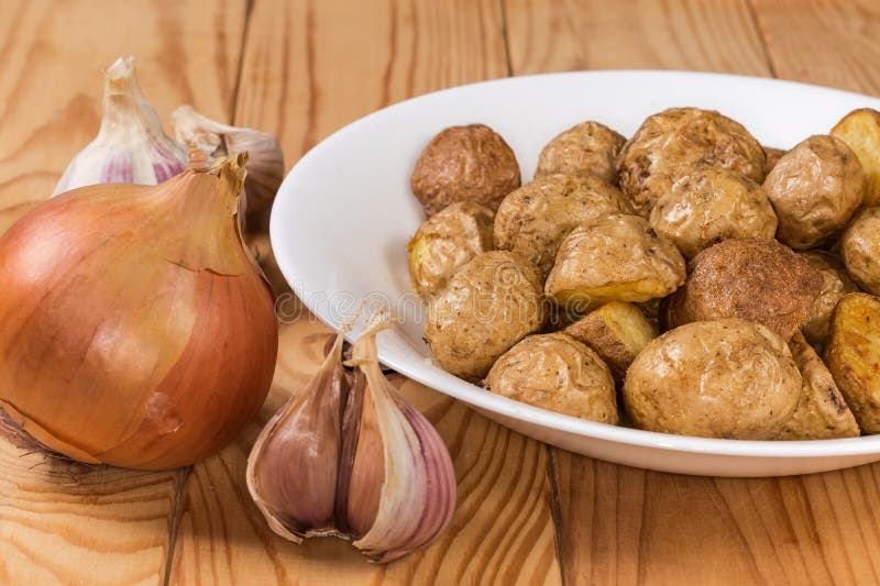 Pezzi di patata cotta in stile contadino su un tavolo immagini stock libere da diritti