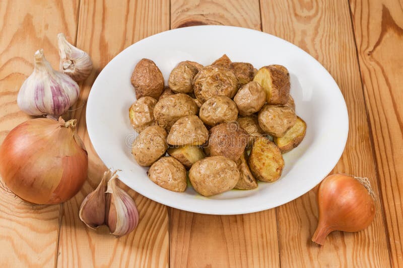 Pezzi di patata cotta in stile contadino su un tavolo immagine stock libera da diritti