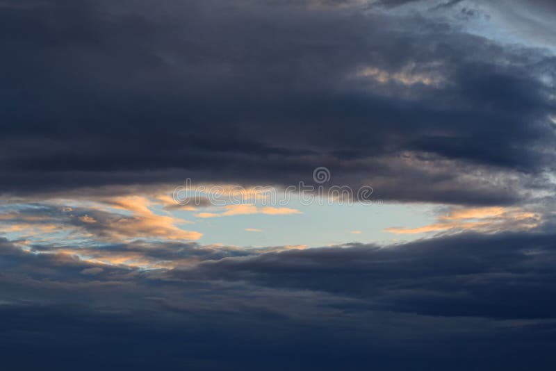 Pezzo di chiaro cielo blu circondato dalle nuvole di tempesta immagini stock Pezzo di chiaro cielo blu circondato dalle nuvole di tempesta immagini stock