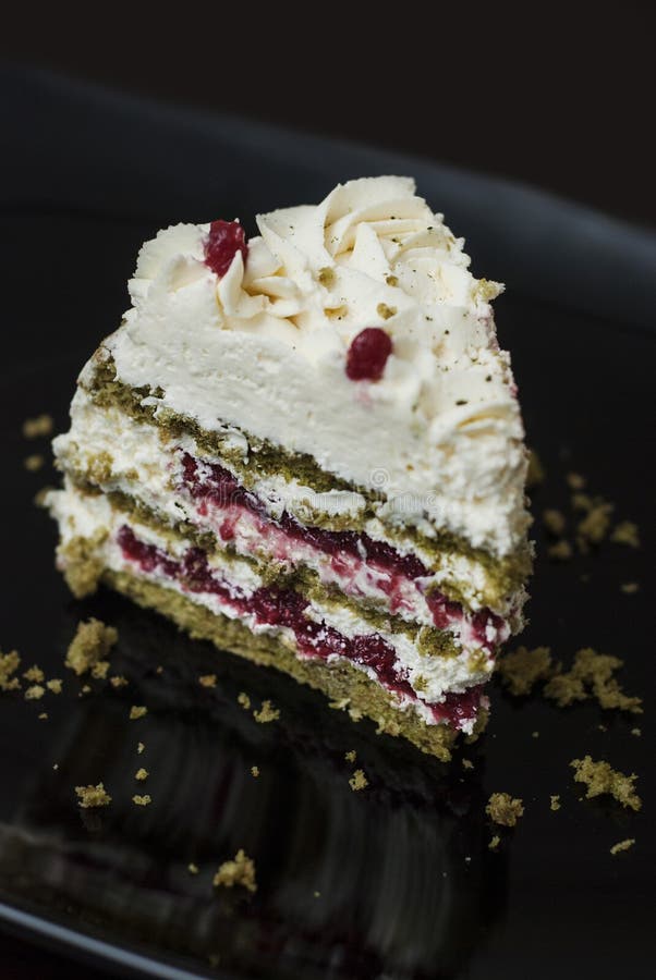 Pezzo di dolce variopinto di Matcha Strawbery con crema e tè verde bianchi, sulla banda nera Ricetta casalinga unica del dolce immagini stock Pezzo di dolce variopinto di Matcha Strawbery con crema e tè verde bianchi, sulla banda nera Ricetta casalinga unica del dolce immagini stock