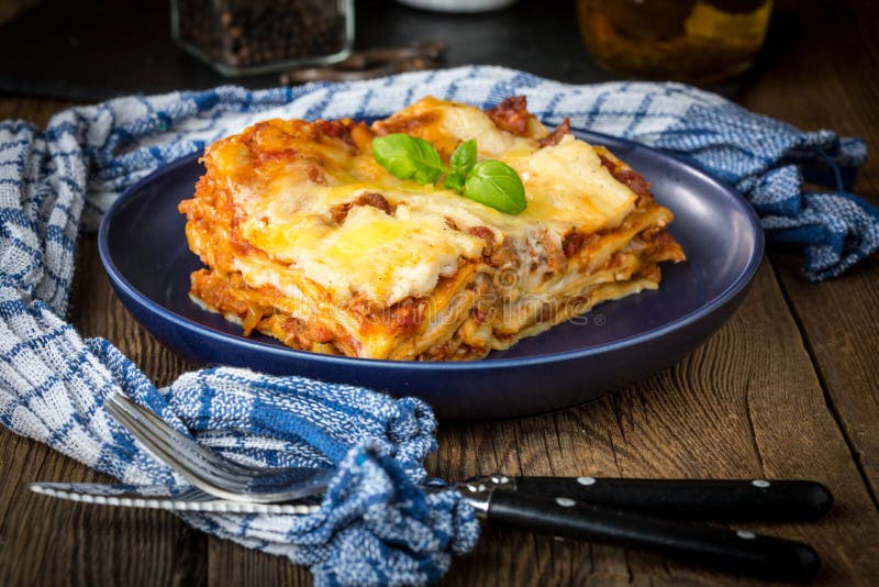 Pezzo di lasagne al forno calde saporite con vino rosso immagine stock libera da diritti Pezzo di lasagne al forno calde saporite con vino rosso immagine stock libera da diritti