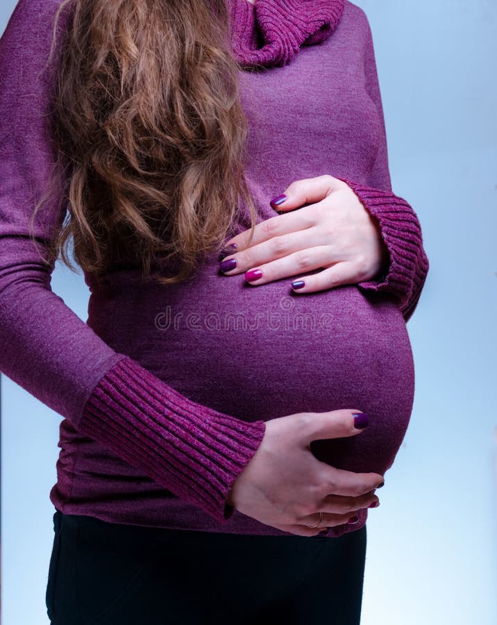Pełna długość caucasian, kobieta w ciąży pobyt w studiu zamyka w górę żołądka na ręka z manicure'u chwyta brzuchem Szczęśliwy obrazy royalty free Pełna długość caucasian, kobieta w ciąży pobyt w studiu zamyka w górę żołądka na ręka z manicure'u chwyta brzuchem Szczęśliwy obrazy royalty free