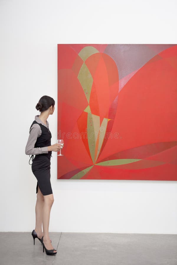 Pełna długość kobieta patrzeje obraz w galerii sztuki