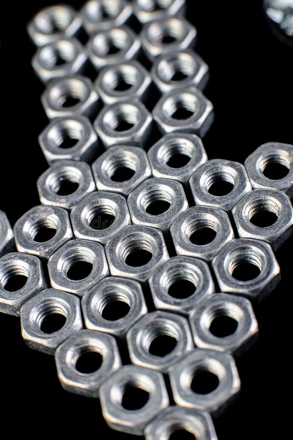 Pfeil von den Metallnüssen, Bolzen auf schwarzem Hintergrund Flache Lage Makro stockfoto Pfeil von den Metallnüssen, Bolzen auf schwarzem Hintergrund Flache Lage Makro stockfoto